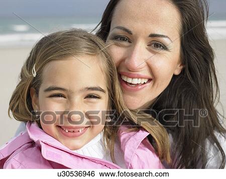 Stock Photograph - Young girl (6-8) and mother, close-up, portrait. Alicante, Spain.. Fotosearch