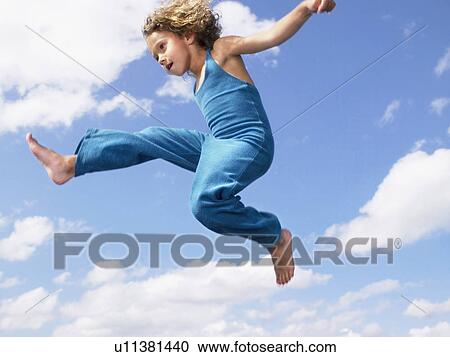 Stock Image - Young girl jumping in the air.. Fotosearch