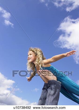 Stock Image - Young girl swirling feet in the air.. Fotosearch