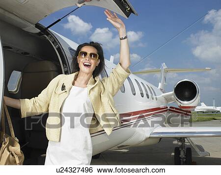 Stock Photograph - Happy female exiting corporate Jet.. Fotosearch