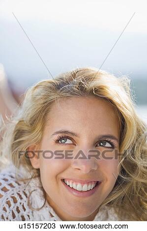 Stock Image - Woman relaxing by a pool.. Fotosearch