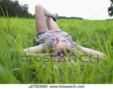 Woman resting in a green field. View Large Photo Image Stock Image - Woman resting in a green field.. Fotosearch