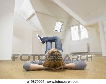 Woman resting on her back on the wooden floor of empty white loft. View Large Photo Image Stock Photography - Woman resting on her back on the wooden floor of empty white loft.. Fotosearch
