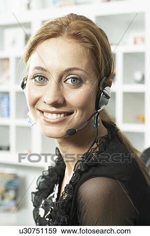 Stock Photo - Woman smiling on headset. Fotosearch
