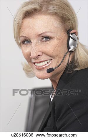 Woman smiling on headset View Large Photo Image Stock Photograph - Woman smiling on headset. Fotosearch