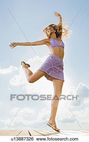 Young woman jumping in the air. View Large Photo Image Stock Photograph - Young woman jumping in the air.. Fotosearch