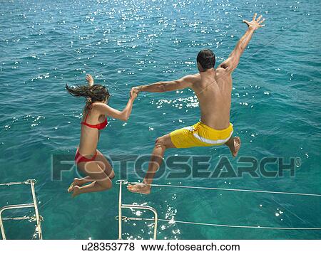 Couple jumping into sea from boat, rear view View Large Photo Image Stock Photo - Couple jumping into sea from boat, rear view. Fotosearch