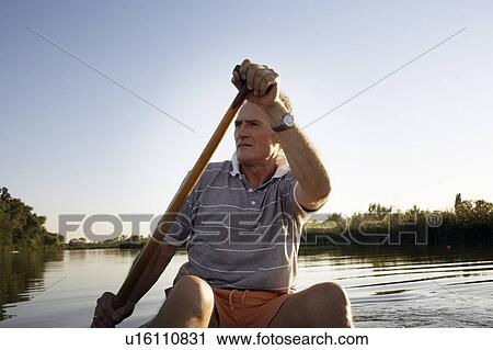 Man rowing a canoe. View Large Photo Image Stock Image - Man rowing a canoe.. Fotosearch
