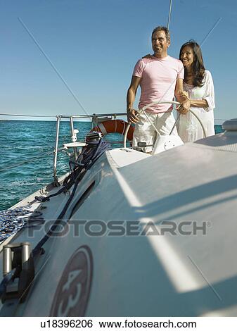 Mature couple at wheel of yacht, smiling View Large Photo Image Stock Photograph - Mature couple at wheel of yacht, smiling. Fotosearch