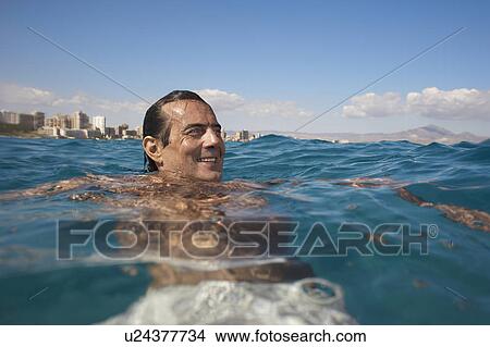 Picture - Mature man swimming in sea, smiling. Fotosearch