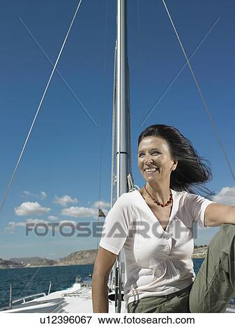 Mature woman relaxing on yacht, smiling View Large Photo Image Stock Photo - Mature woman relaxing on yacht, smiling. Fotosearch