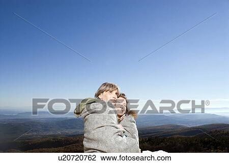 Stock Image - Portrait of a couple in a blanket.. Fotosearch