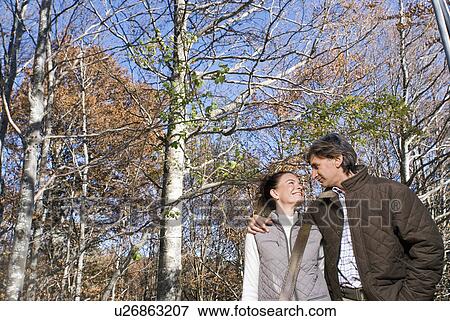 Stock Photo - Portrait of a couple surrounded by trees.. Fotosearch