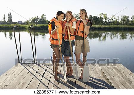 Three young women on a pier with oars. View Large Photo Image Stock Image - Three young women on a pier with oars.. Fotosearch
