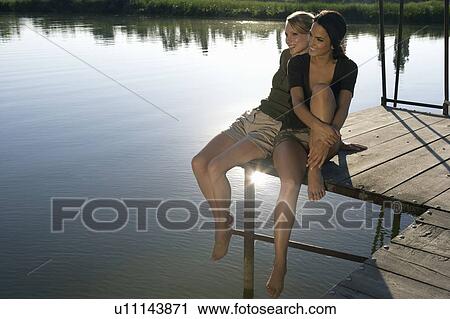 Two young women on a pier. View Large Photo Image Stock Image - Two young women on a pier.. Fotosearch