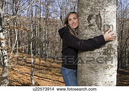 Woman taking a tree in her arms. View Large Photo Image Picture - Woman taking a tree in her arms.. Fotosearch