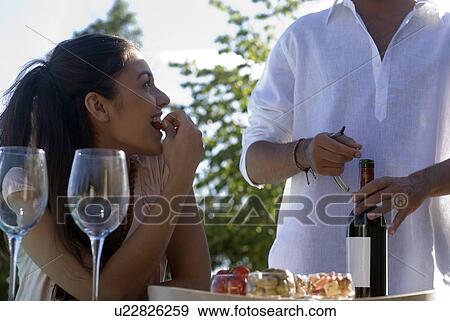 Young couple enjoying wine and appetizers View Large Photo Image Stock Photo - Young couple enjoying wine and appetizers. Fotosearch