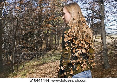 Picture - Young woman covered with leafs.. Fotosearch