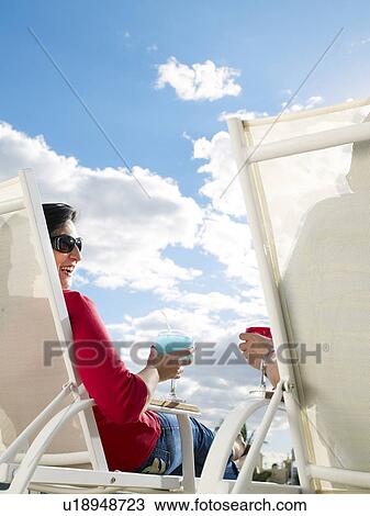 Couple relaxing in deckchairs, rear view View Large Photo Image Stock Image - Couple relaxing in deckchairs, rear view. Fotosearch