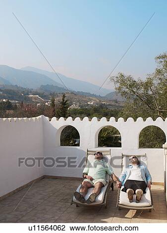 Senior couple sunbathing on balcony terrace View Large Photo Image Stock Image - Senior couple sunbathing on balcony terrace. Fotosearch