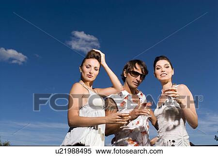 Stock Photography - Three people with drinks outdoors. Fotosearch