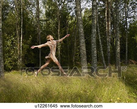 Woman jumping in a forest smiling. View Large Photo Image Stock Photography - Woman jumping in a forest smiling.. Fotosearch