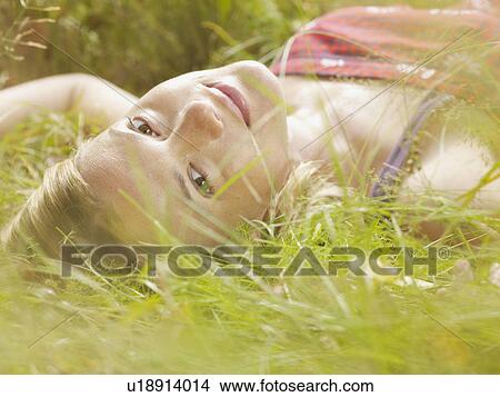 Woman lying in grass. View Large Photo Image Picture - Woman lying in grass.. Fotosearch