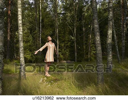 Woman standing on a large rock in forest. View Large Photo Image Stock Image - Woman standing on a large rock in forest.. Fotosearch