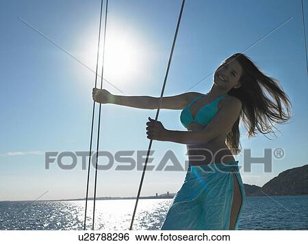 Young woman holding ropes on yacht, smiling View Large Photo Image Stock Photograph - Young woman holding ropes on yacht, smiling. Fotosearch