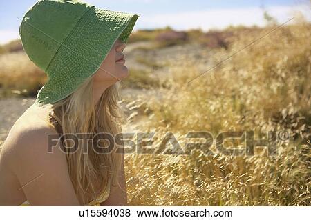 Stock Photo - Young Woman Sitting in Long grass.. Fotosearch