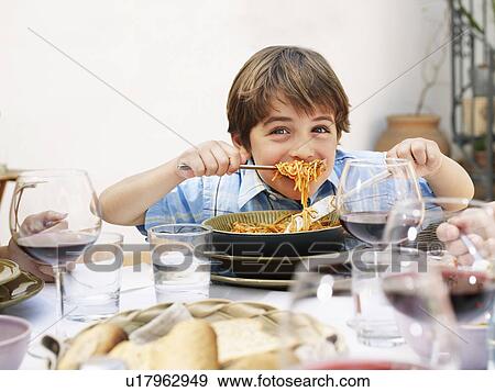 Stock Photo - Boy (4-6) eating spaghetti, smiling, portrait. Fotosearch