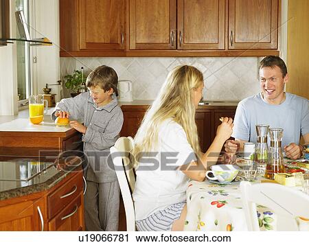 Family eating breakfast in kitchen smiling. View Large Photo Image Stock Image - Family eating breakfast in kitchen smiling.. Fotosearch