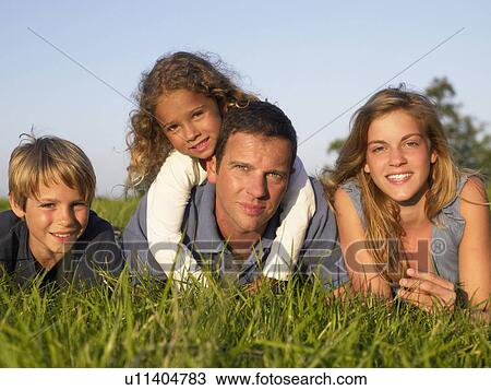 Family lying in a field. View Large Photo Image Stock Image - Family lying in a field.. Fotosearch