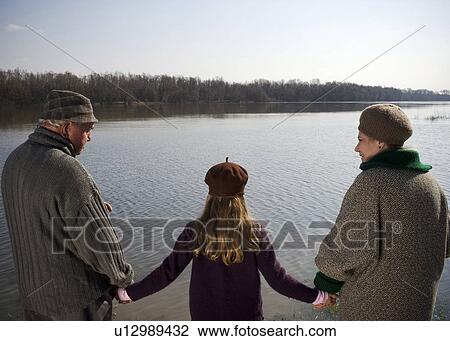 Grandparents holding hands with granddaughter (10-12) by river View Large Photo Image Stock Image - Grandparents holding hands with granddaughter (10-12) by river. Fotosearch