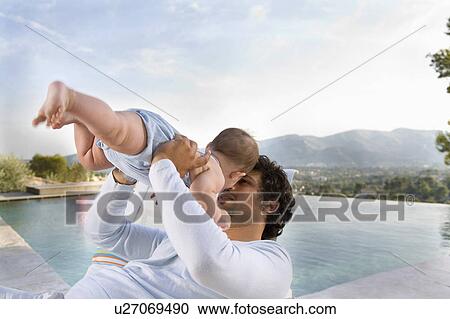 Stock Image - Man holding baby.. Fotosearch