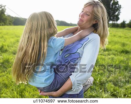 Stock Photo - Mother and daughter playing in a field.. Fotosearch