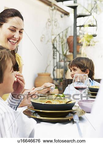 Mother and two sons (5-7) having lunch in garden, smiling View Large Photo Image Stock Photograph - Mother and two sons (5-7) having lunch in garden, smiling. Fotosearch
