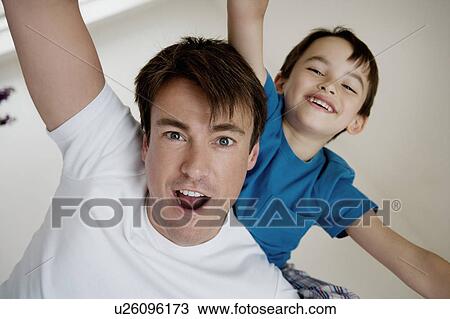 Stock Image - Portrait of a father and son playing.. Fotosearch