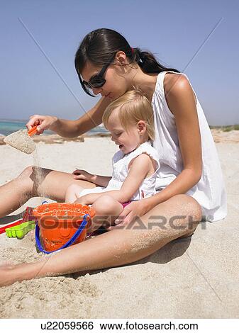 Stock Photograph - Woman and smiling young boy at the beach playing.. Fotosearch