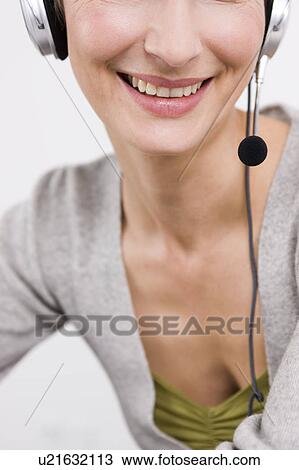 Stock Image - Close up woman with headset smiling. Fotosearch