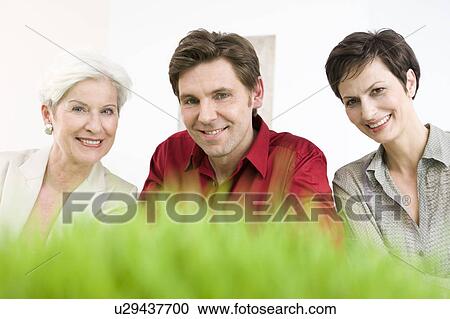 Man and two women in front of grass View Large Photo Image Stock Image - Man and two women in front of grass. Fotosearch