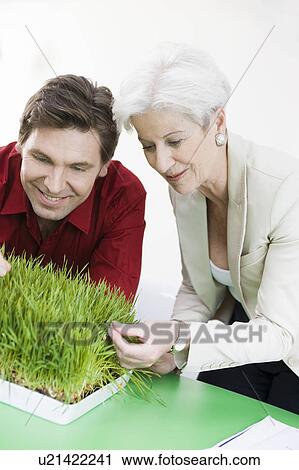 Stock Image - Man and woman feeling some grass. Fotosearch