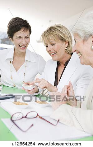 Picture - Team of women tasting some corn. Fotosearch