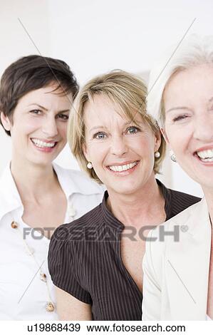 Stock Photo - Three women laughing into camera. Fotosearch