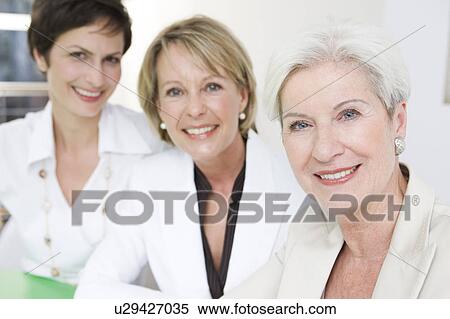 Three women looking into camera View Large Photo Image Stock Photography - Three women looking into camera. Fotosearch