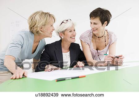 Stock Photo - Three women studying some papers. Fotosearch