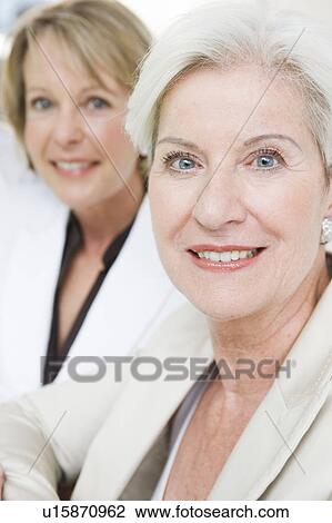 Two women looking into camera View Large Photo Image Stock Image - Two women looking into camera. Fotosearch