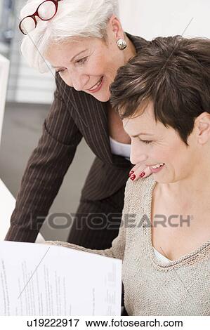 Two women studying some papers View Large Photo Image Stock Photo - Two women studying some papers. Fotosearch