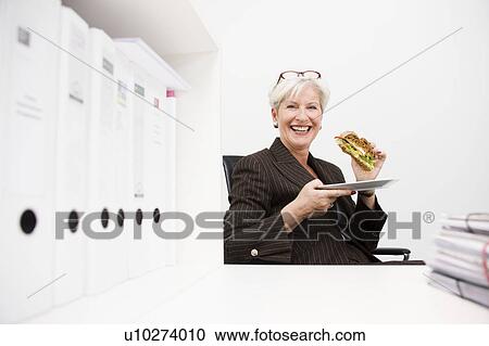 Stock Image - Woman eating a sandwich. Fotosearch