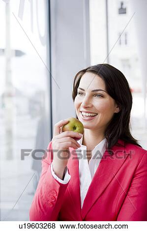 Stock Photo - Woman eating an apple. Fotosearch